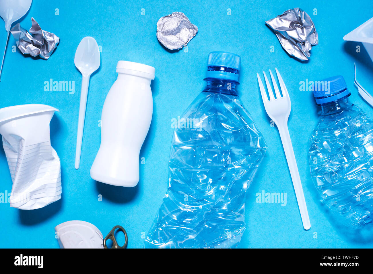 Plastic trash on blue background, eco concept image. Stock Photo