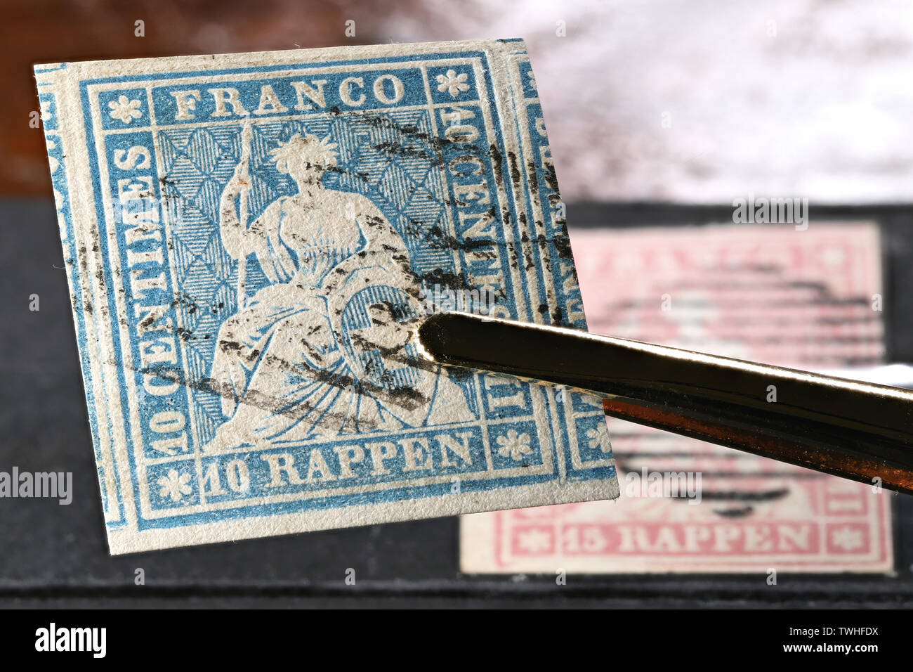 Swiss 10 Rappen Strubel stamp held by tweezers. Stock Photo