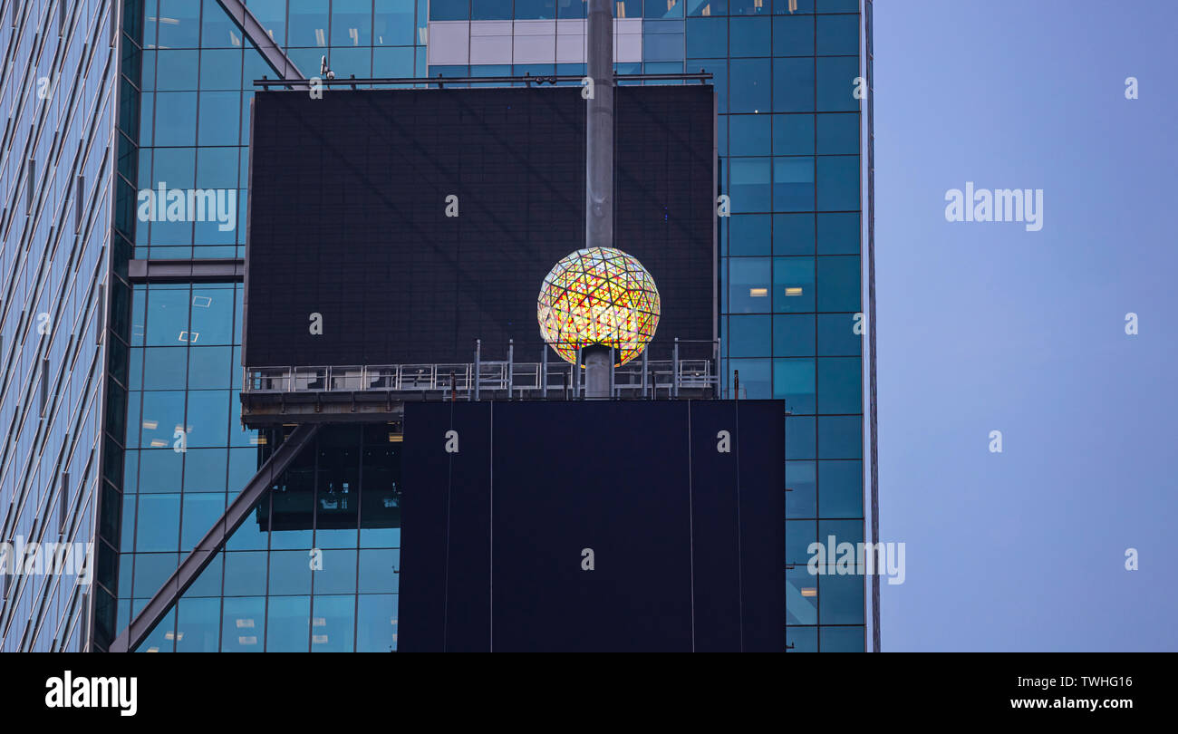 USA, New York, Times Square. May 2, 2019. Colorful crystal new years eve ball and black blank billboards on glass skysraper facade background. Stock Photo