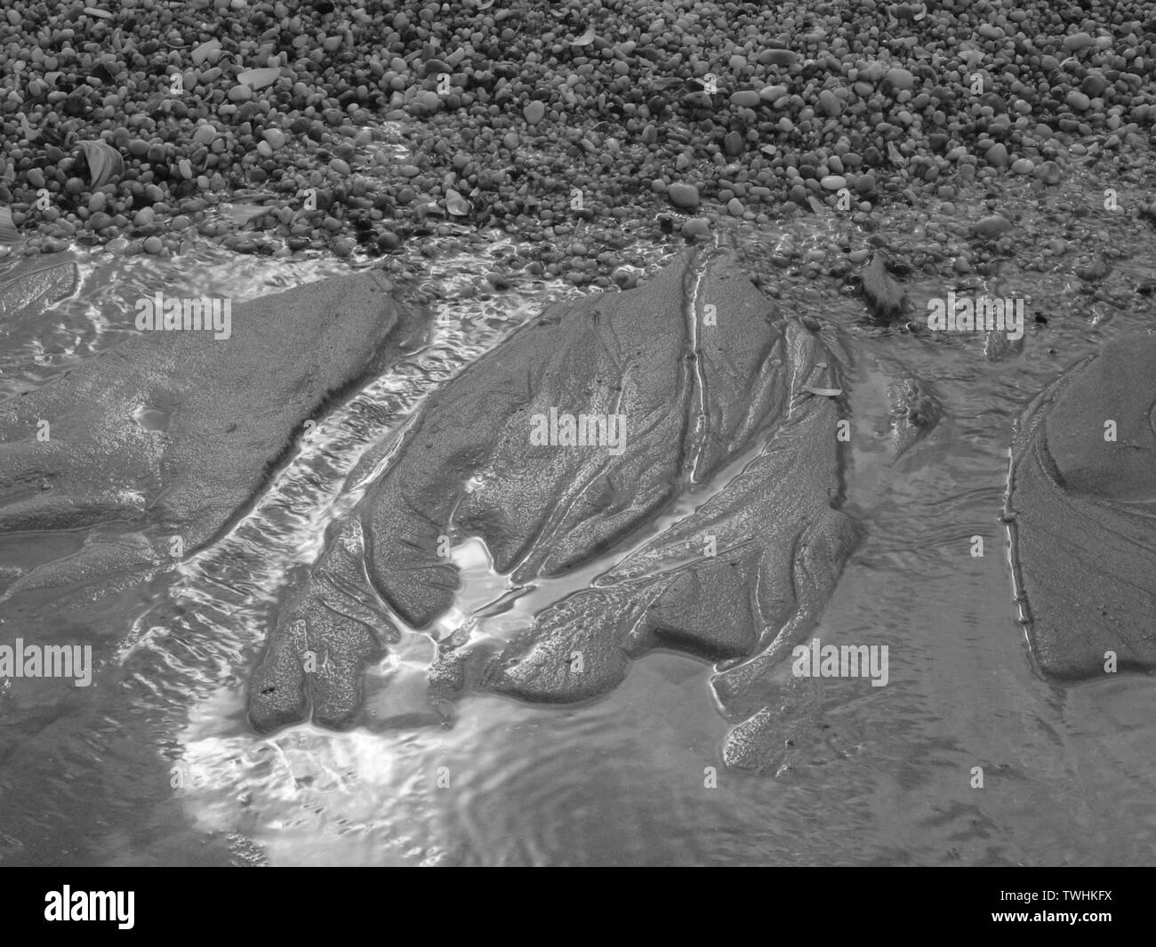 Black and white abstracts of sand on beach with flowing water Stock ...