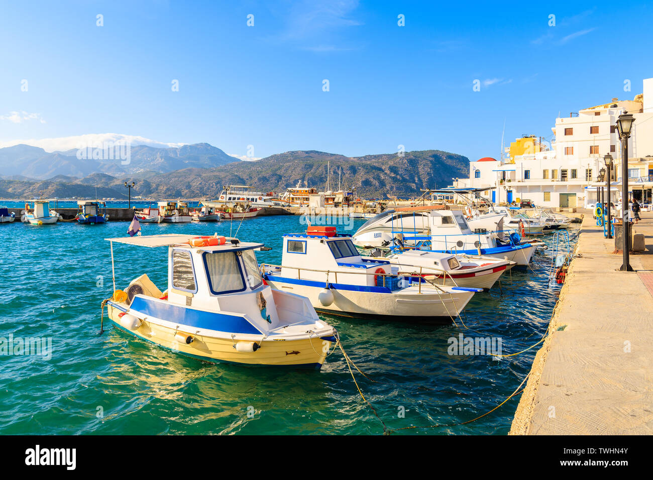 Fishing boats in picturesque Pigadia port on Karpathos island at sunset time, Greece Stock Photo