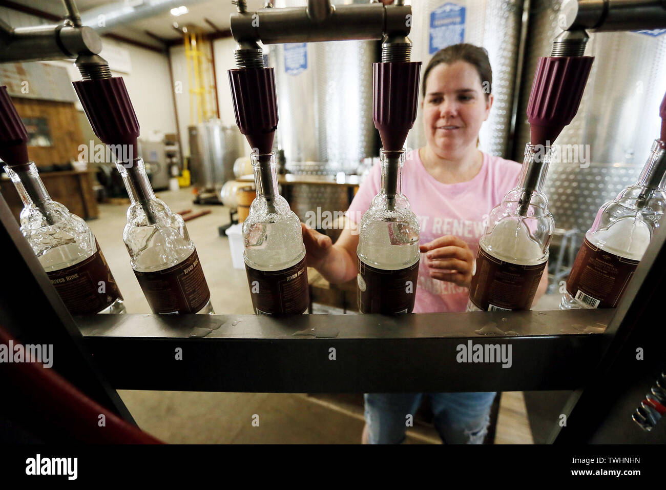 Le Claire, Iowa, USA. 20th June, 2019. Distiller Kathryn Langford fills bottles with River Rose