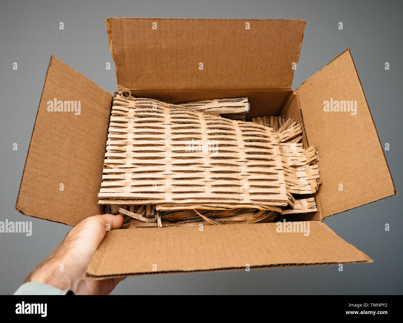 holding open cardboard box after before unboxing with protective paper  carton Stock Photo - Alamy