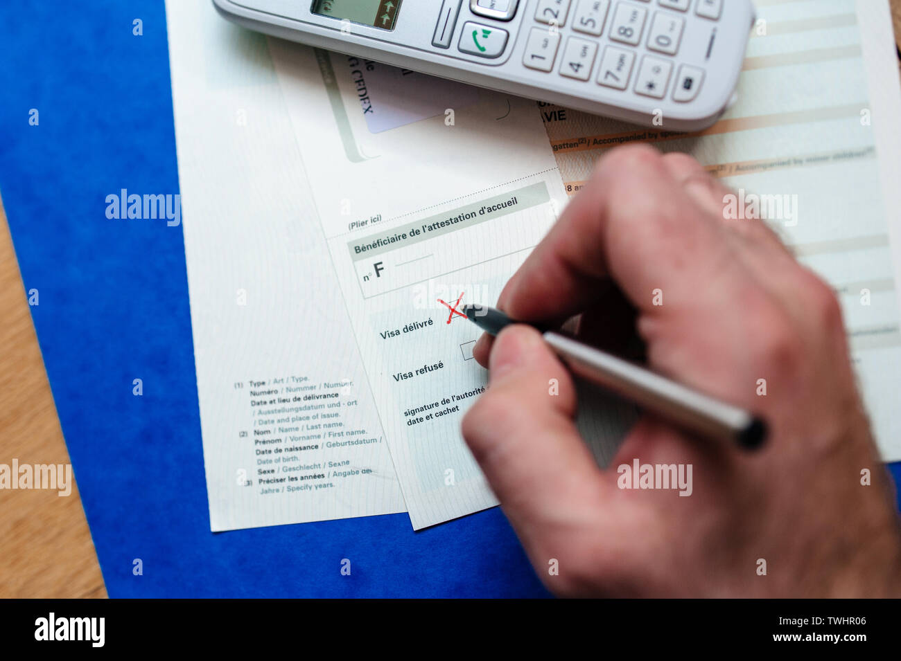 Paris, France - Apr 10, 2013: Man hand filling Attestation d'accueil Proof  of Accommodation for visitors from other countries to France - signing Visa  delivered Stock Photo - Alamy