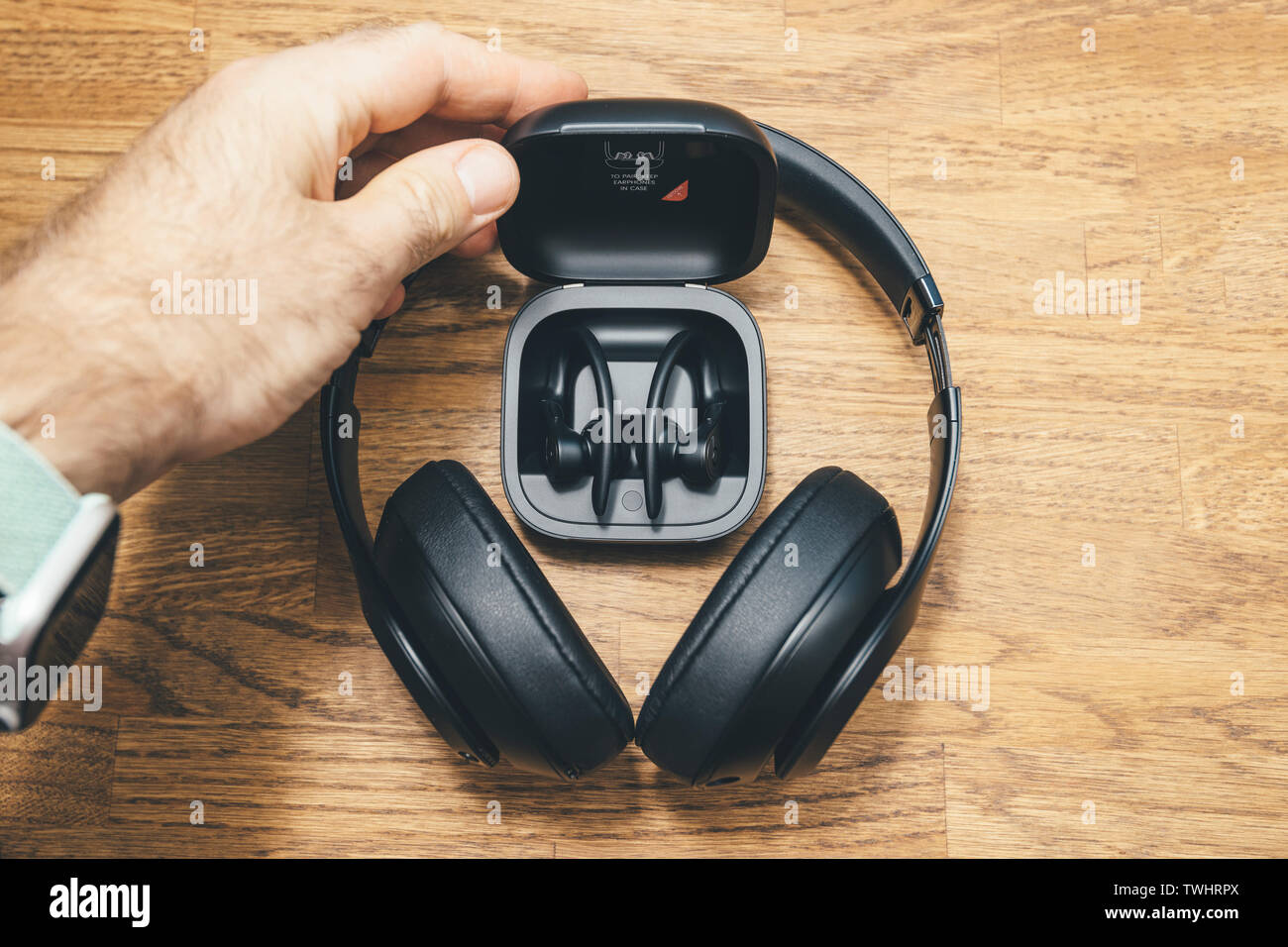 Paris, France - Jun 17, 2019: Man hand talking from table Beats Studio 3 Wireless and Powerbeats Pro Beats in by Dr Dre in charging case wireless high-performance earphone with integrated Siri - directly above view Stock Photo