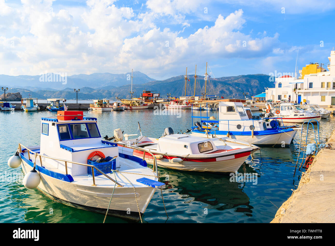 Fishing boats in Pigadia port on Karpathos island at sunset time, Greece Stock Photo