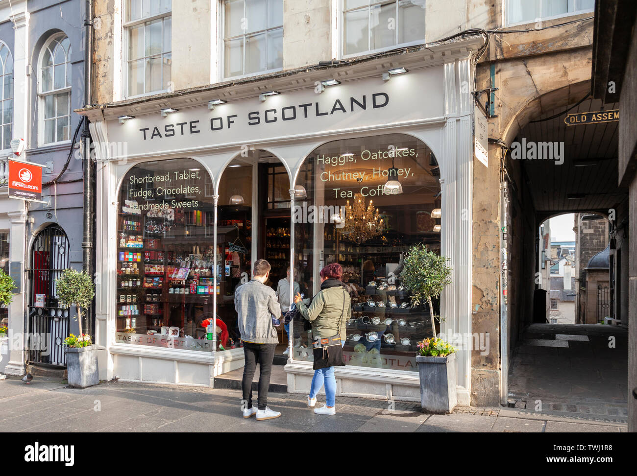 Customers inside and outside the Taste of Scotland shop next to Old Assembly Close in the Royal Mile / High Street, Edinburgh, Scotland, UK Stock Photo