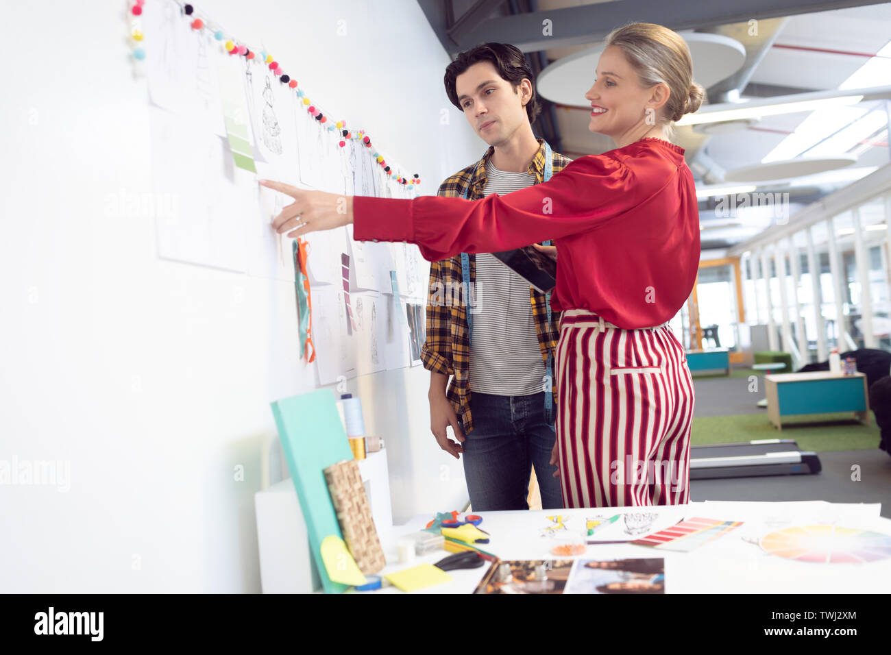 Male and female fashion designer discussing over sketch Stock Photo - Alamy