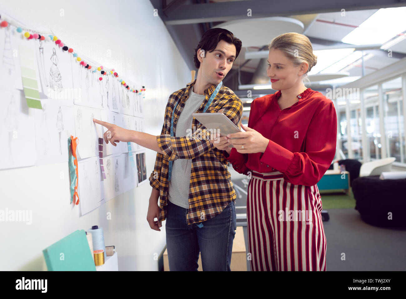 Male and female fashion designer discussing over sketch Stock Photo - Alamy