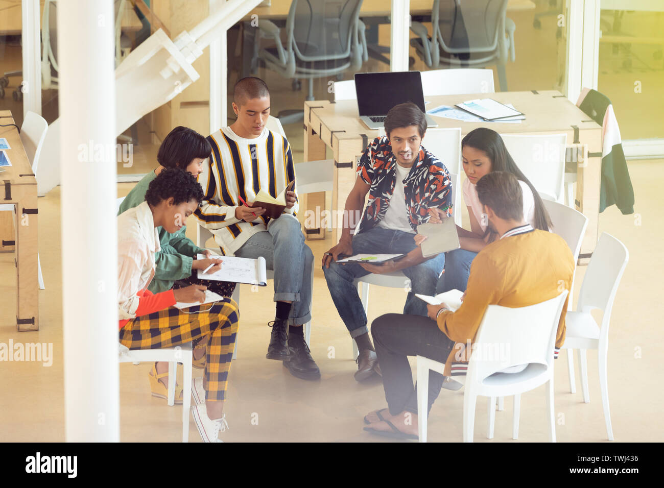 Business people sitting together and having group discussion in office