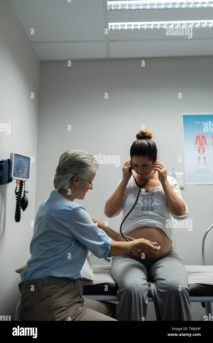 Pregnant woman listening baby heartbeat with stethoscope in hospital Stock  Photo - Alamy