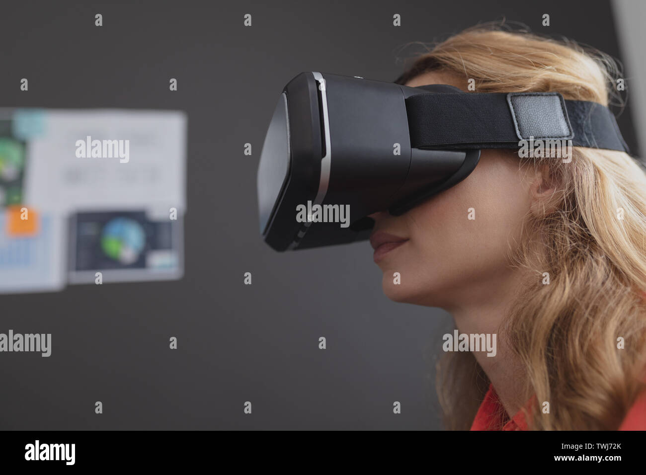 Female executive using virtual reality headset Stock Photo - Alamy