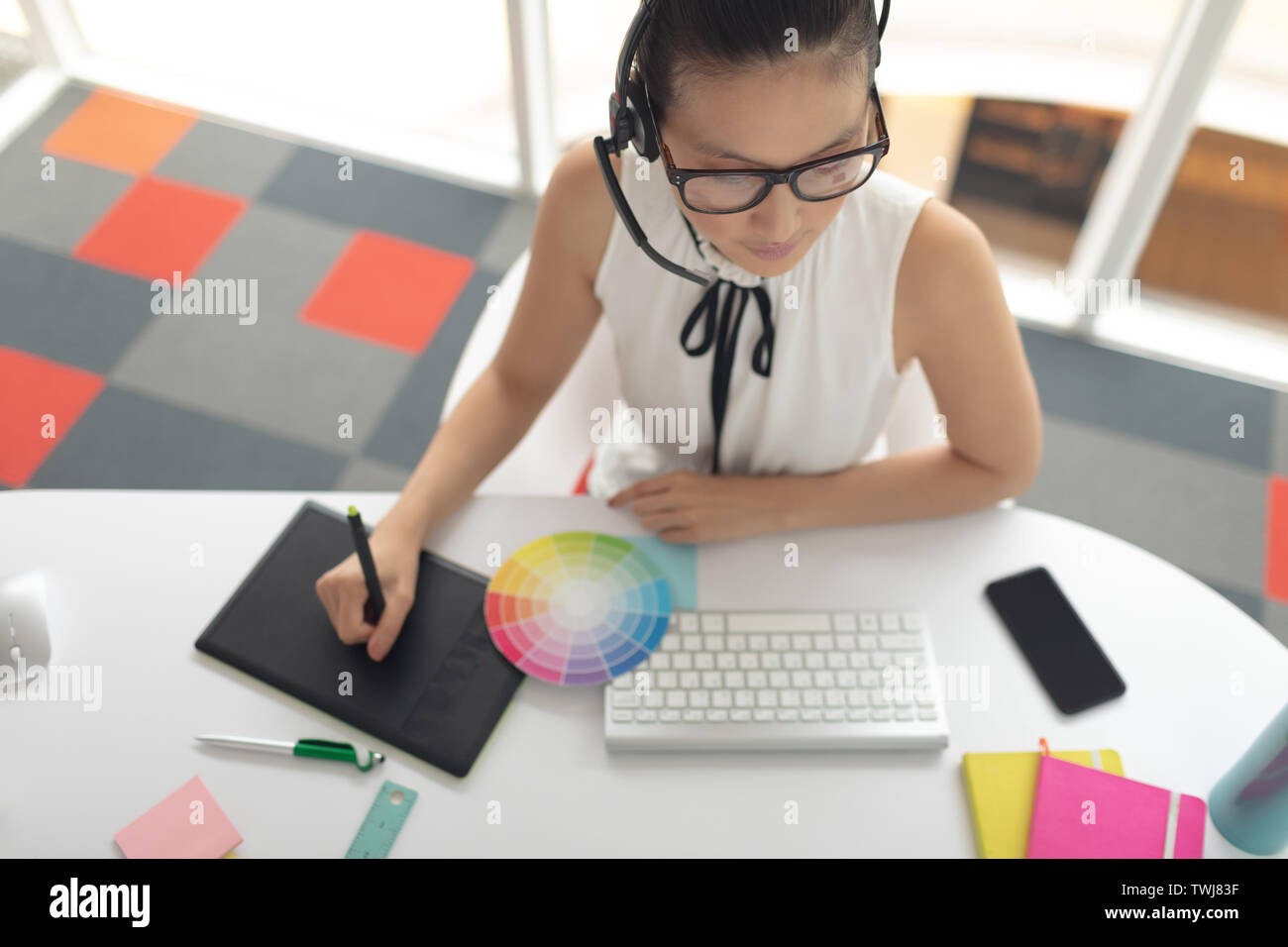 Female graphic designer using graphic tablet at desk in a modern office ...