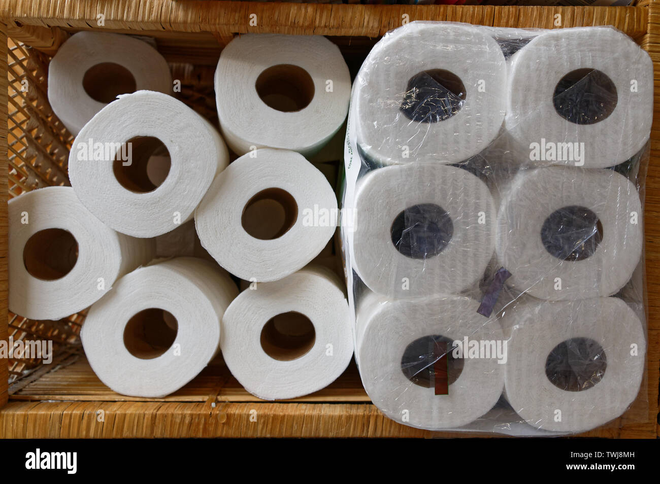 White toilet rolls stacked on their sides in a cane cabinet Stock Photo ...