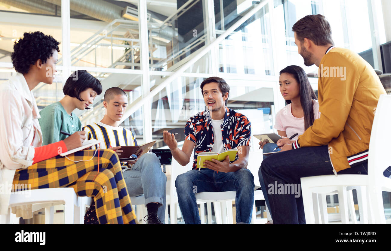 Business people sitting together and having group discussion in office