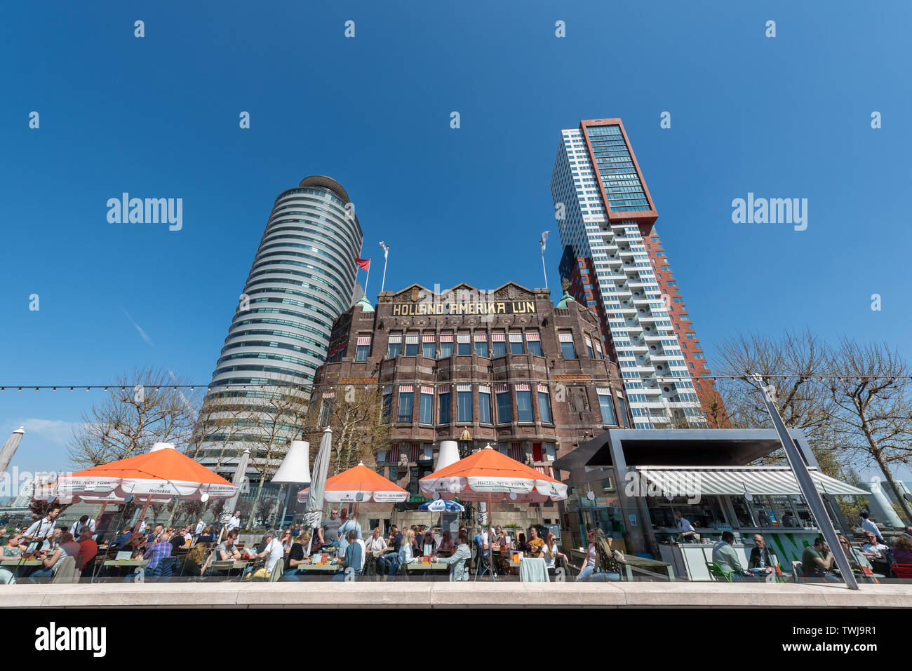 Rotterdam, Netherlands - April 18, 2019 : People having a dring and eating on the terrace of Hotel New York on a sunny day Stock Photo