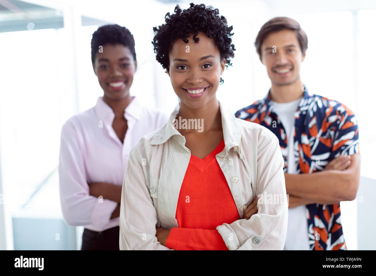 Business people with arms crossed looking at camera in a modern office ...