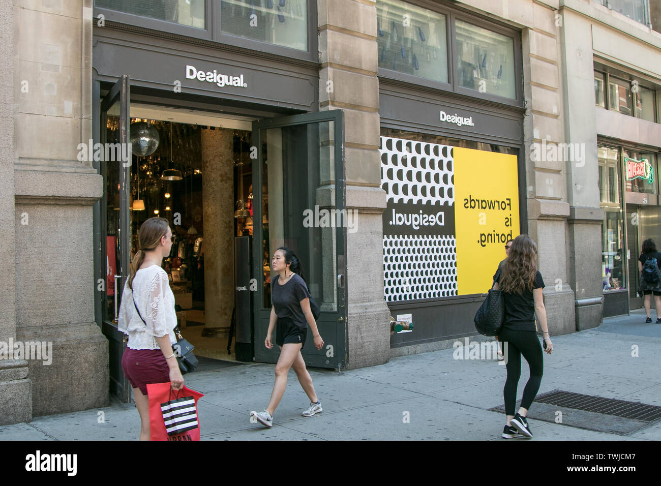 New York, 6/15/2019: People walk by a Desigual store in SoHo. Stock Photo