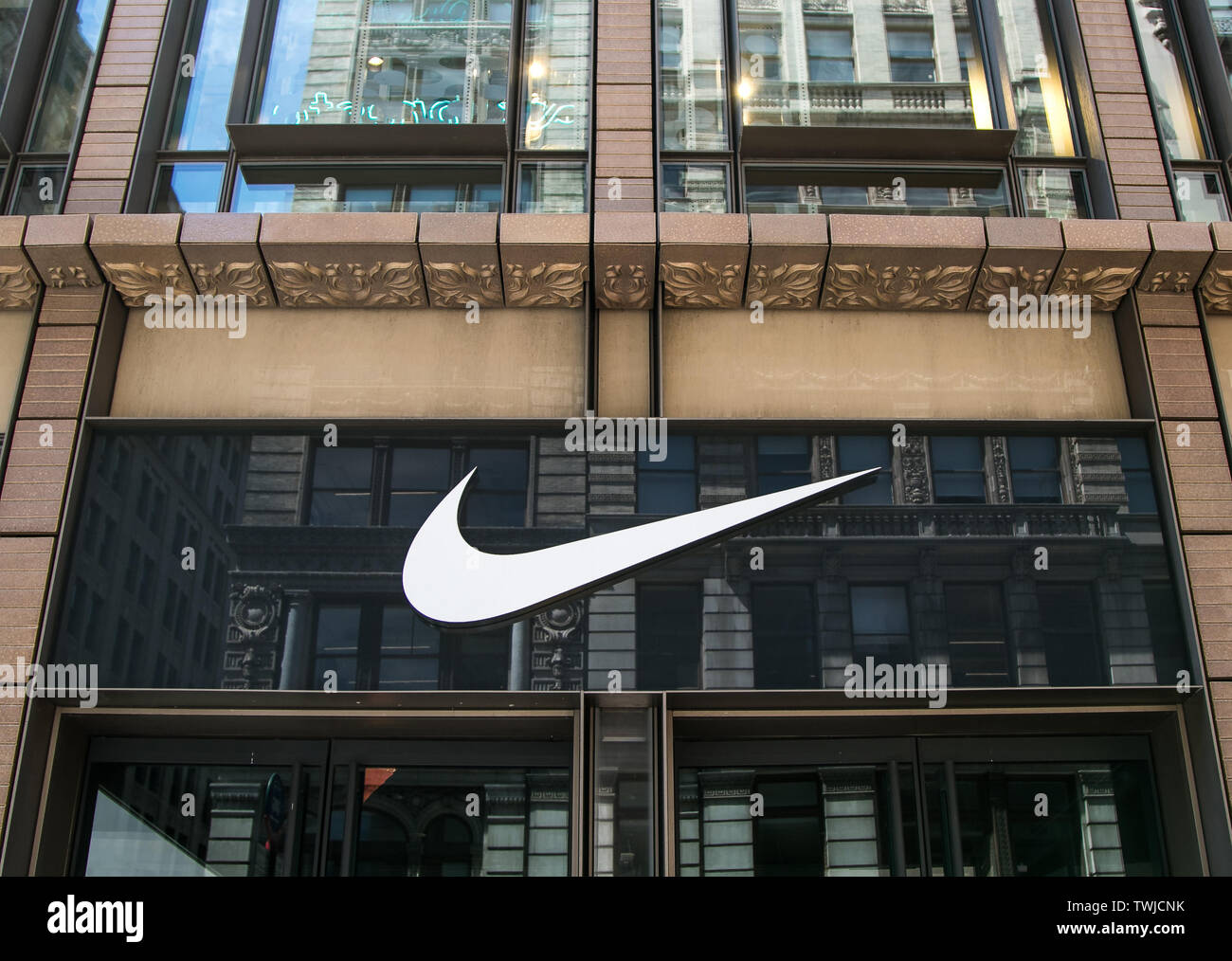New York, 6/15/2019: Nike's logo is displayed above the entrance to their store in SoHo. Stock Photo