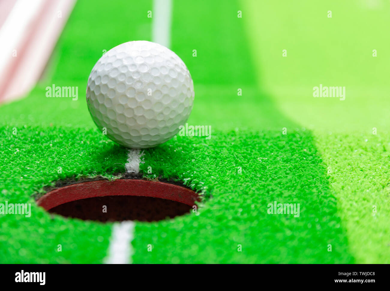 golf ball on lip of cup, goal concept Stock Photo