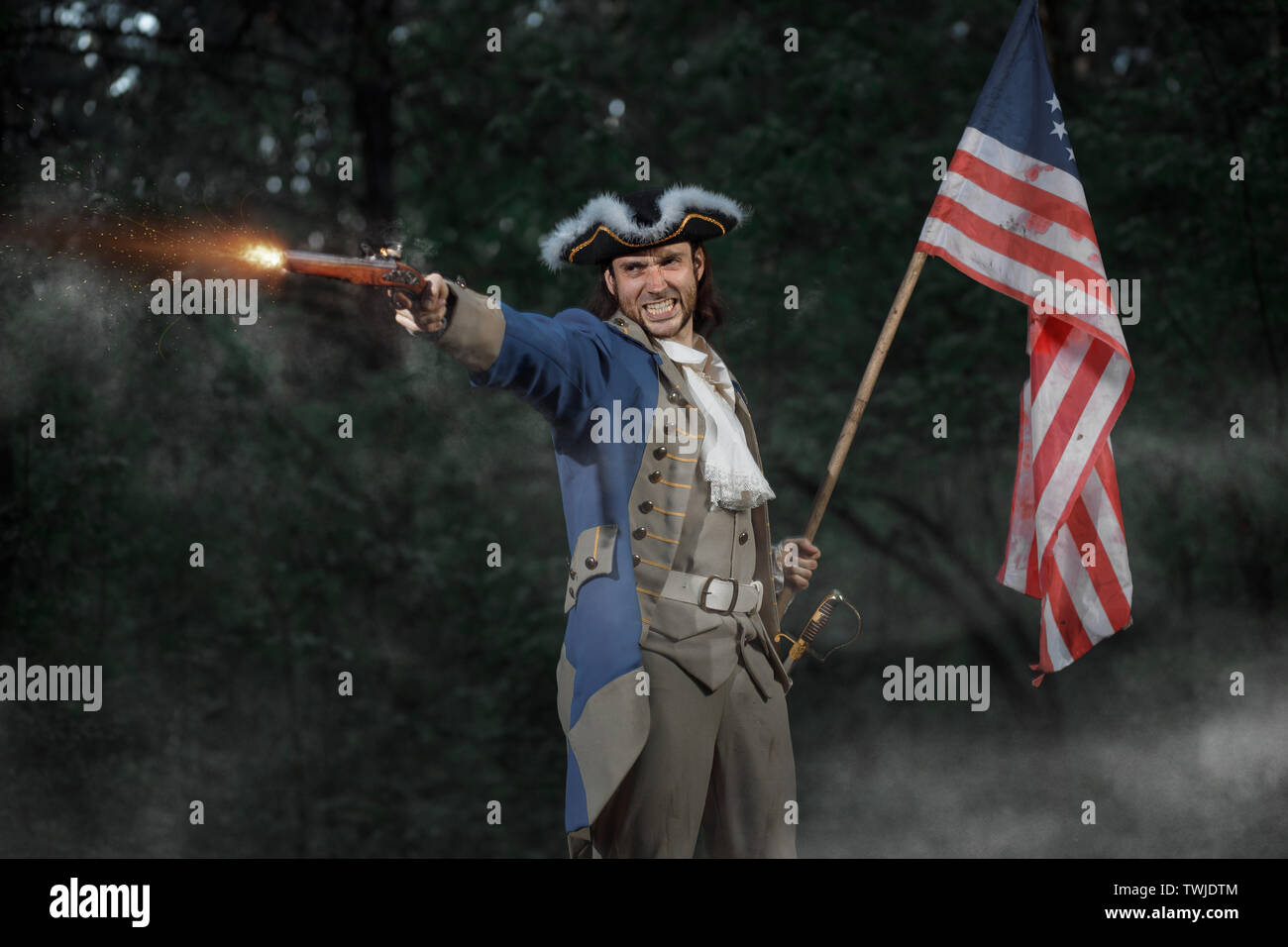 Epic Portrait of man dressed as soldier of american revolution war of United States aims from pistol with flag. 4 july independence day of USA concept Stock Photo