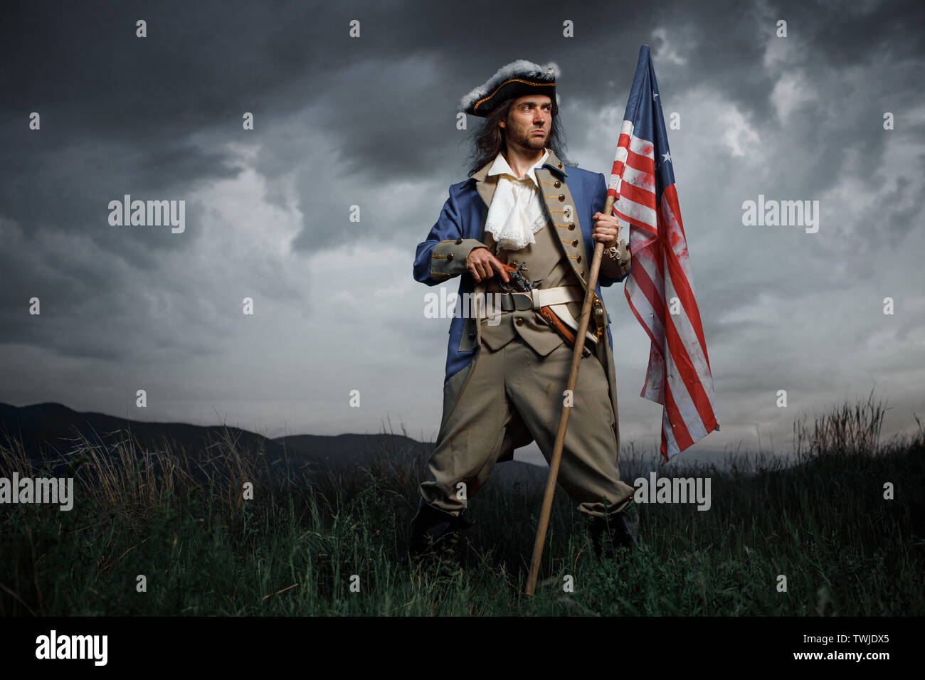 Man in United States War of Independence soldier costume with flag posing in forest. 4 july independence day of USA concept photo composition Stock Photo