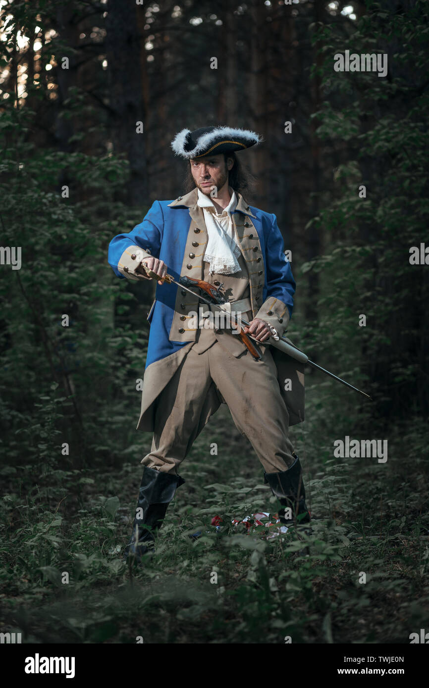 Portrait of man dressed as soldier of War of Independence United States aims from pistol with flag. 4 july independence day of USA concept photo compo Stock Photo