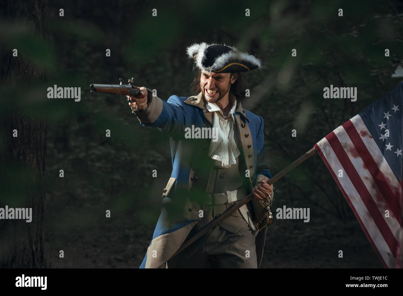 Man dressed as soldier of War of Independence United States aims from pistol with flag.  4 july independence day of USA concept photo composition: sol Stock Photo