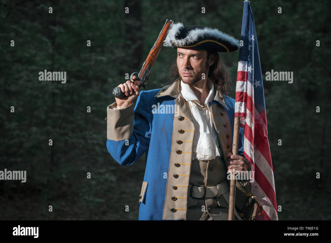Portrait of man dressed as soldier of War of Independence United States aims from pistol with flag. 4 july independence day of USA concept photo compo Stock Photo