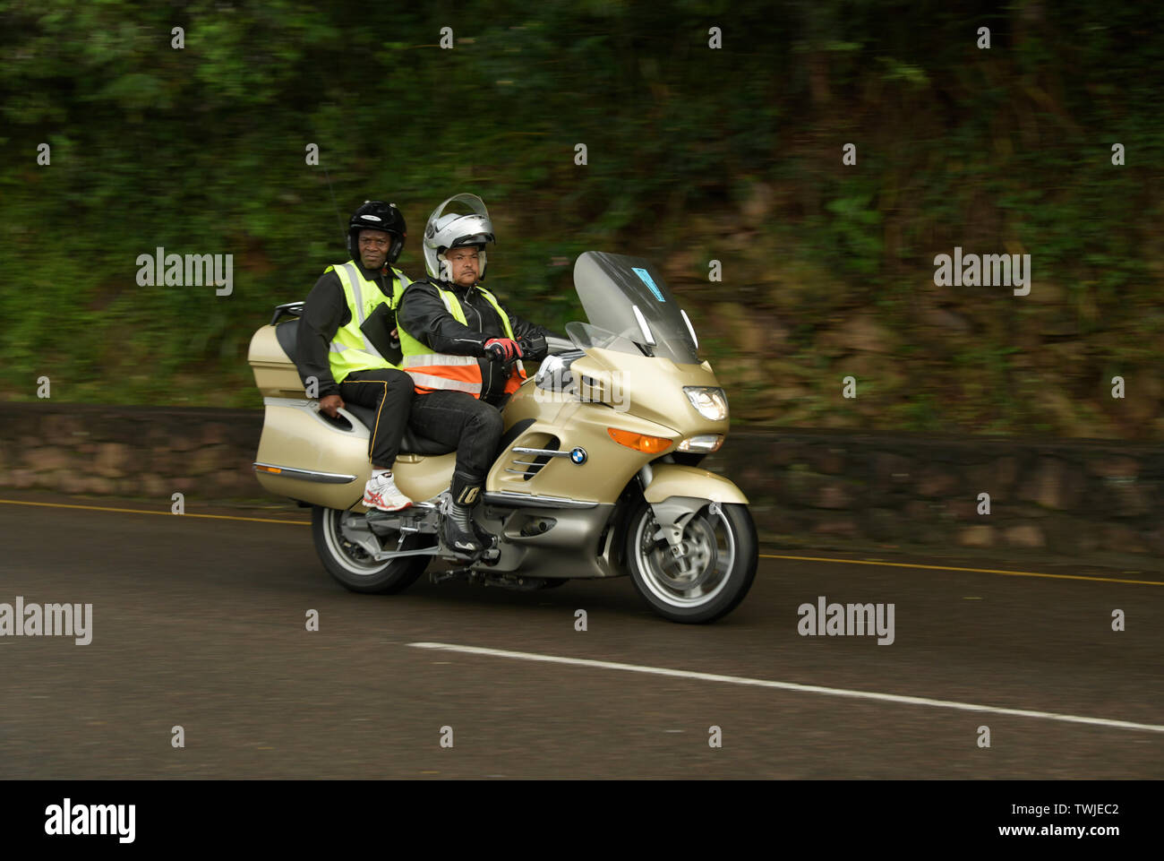 Durban, South Africa, 2 adult men in high visibility clothing riding on