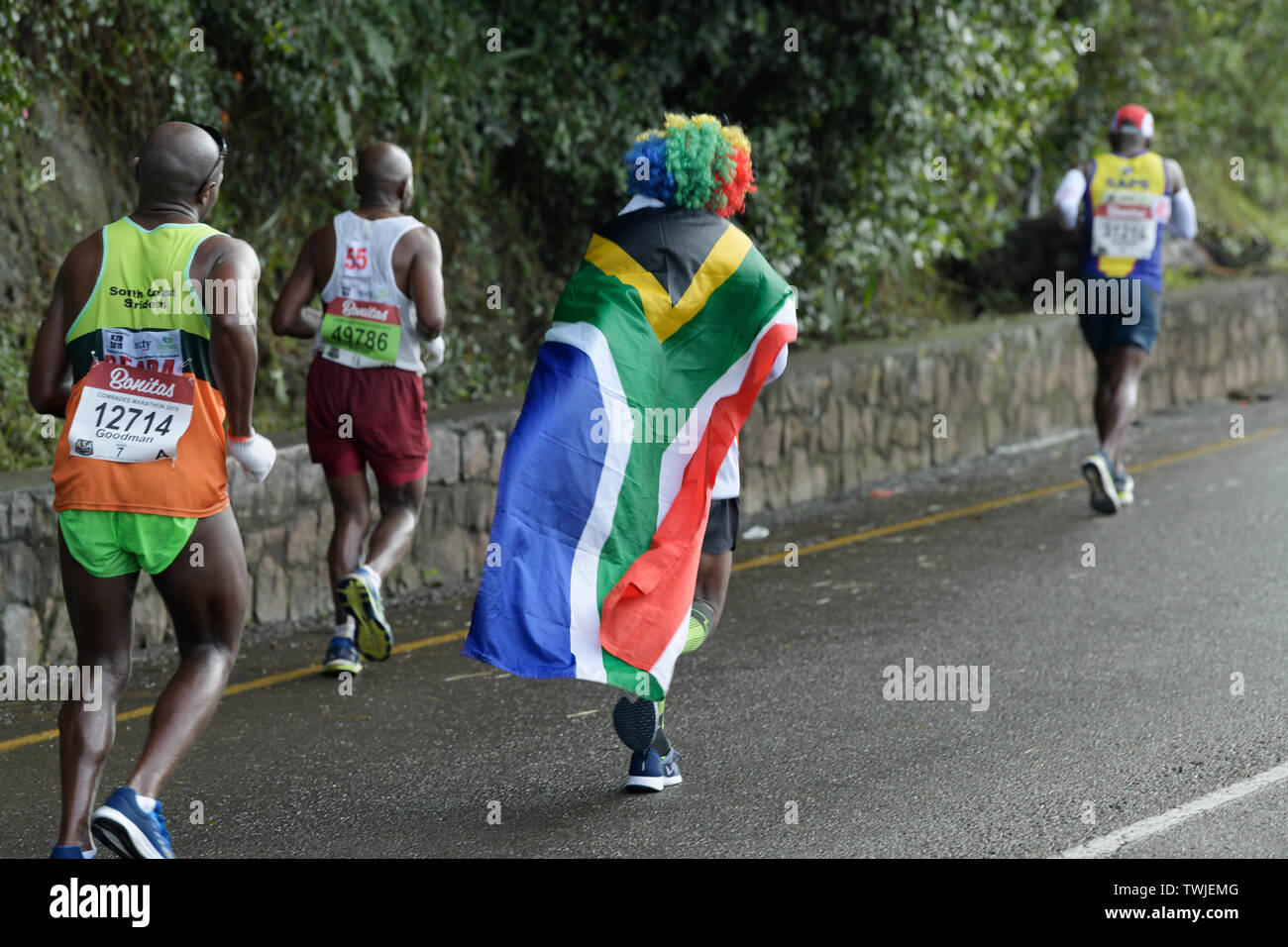 Durban, South Africa, adult man running in 2019 Comrades Marathon, displaying South African flag, runners, sport, people, symbol Stock Photo