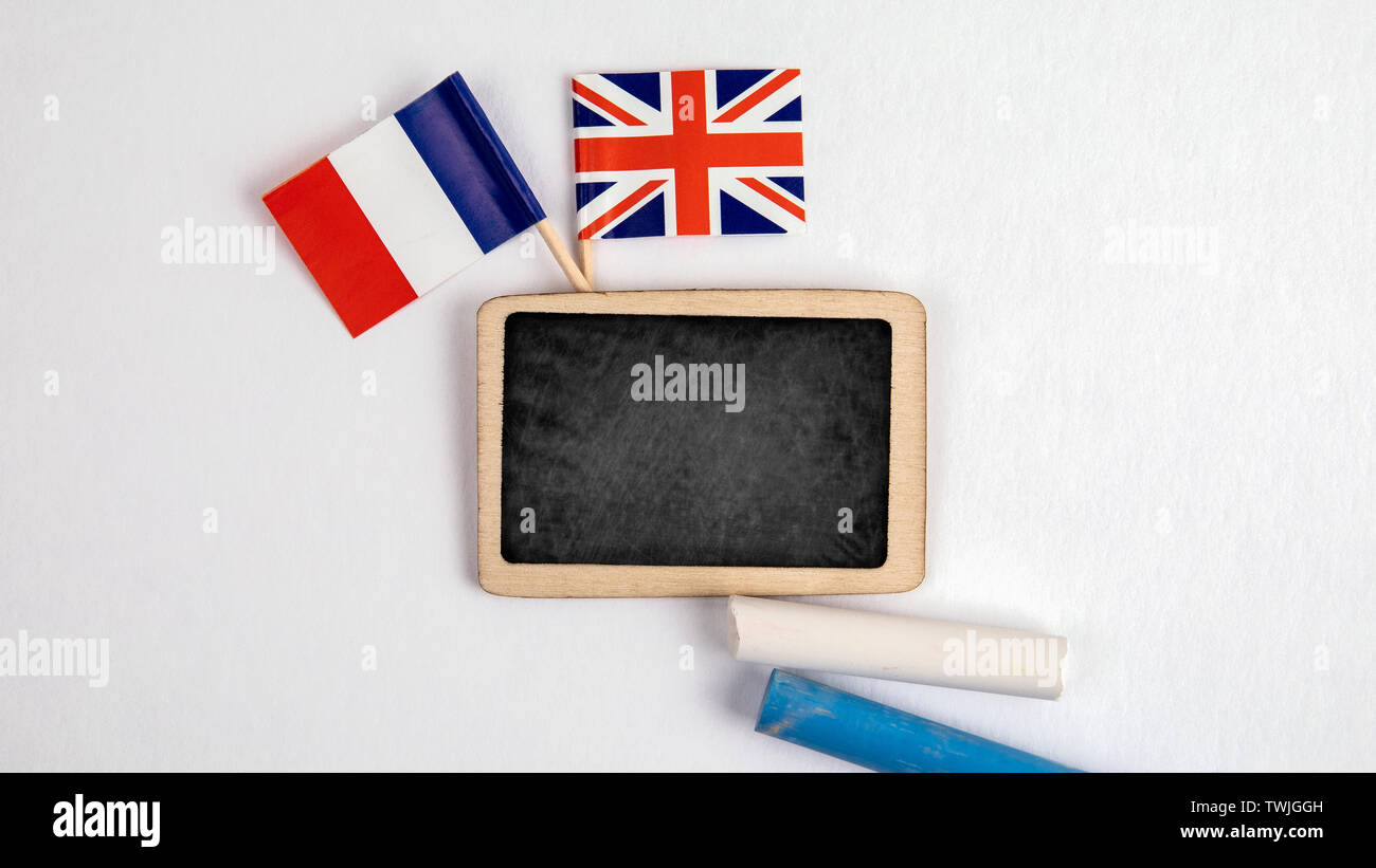 British and French flags. Small whiteboard with chalk. Top view on a