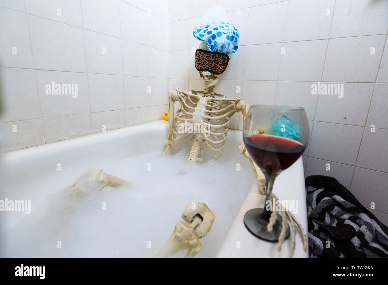 Bony skeleton taking a bubble bath in a grungy off-white dirty tub Stock Photo - Alamy
