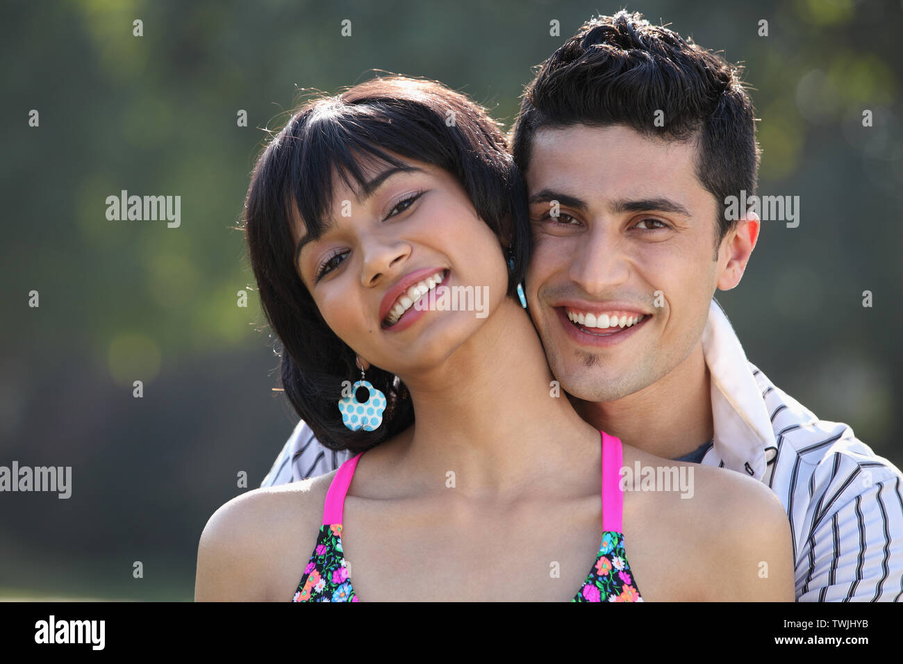 Young man embracing a woman from behind and smiling Stock Photo - Alamy