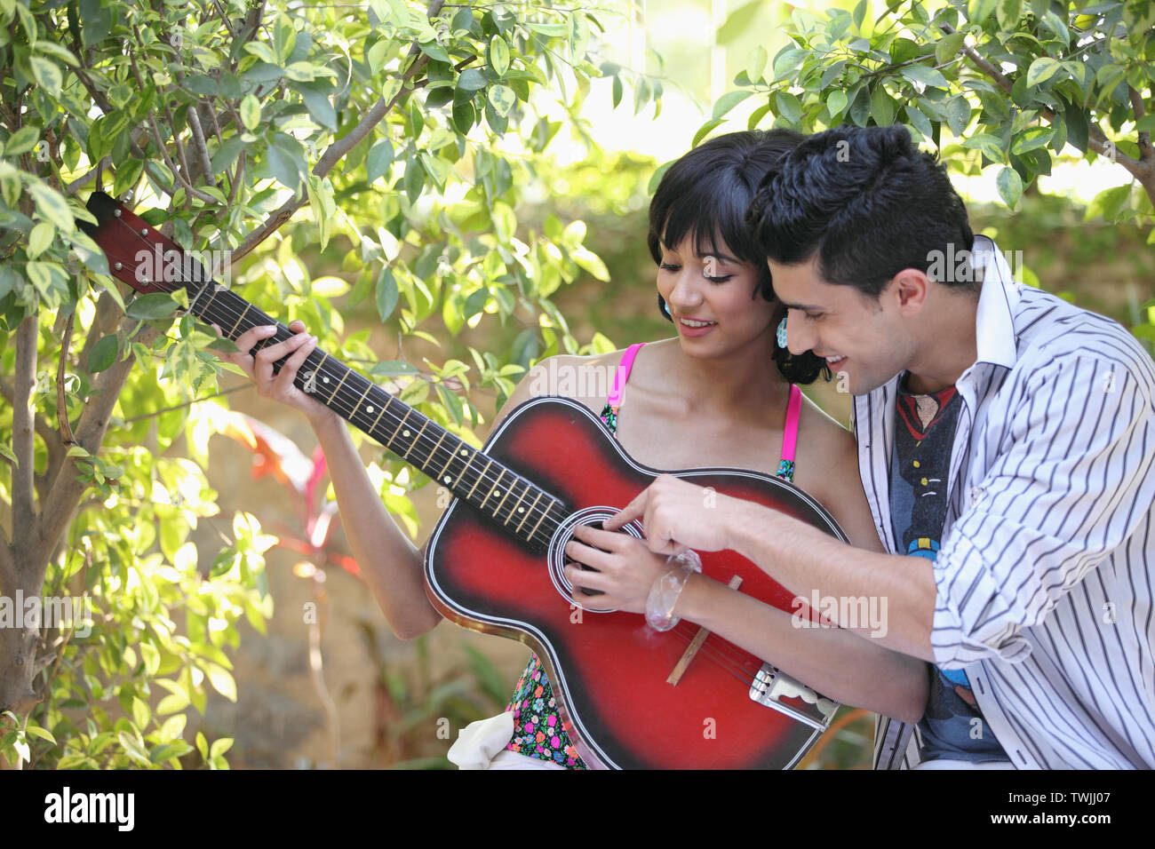 Man teaching how to play guitar to girlfriend at home on day 6699894 Stock  Photo at Vecteezy