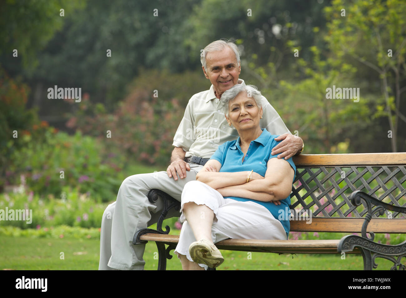 Old couple sitting on a park bench and smiling Stock Photo - Alamy
