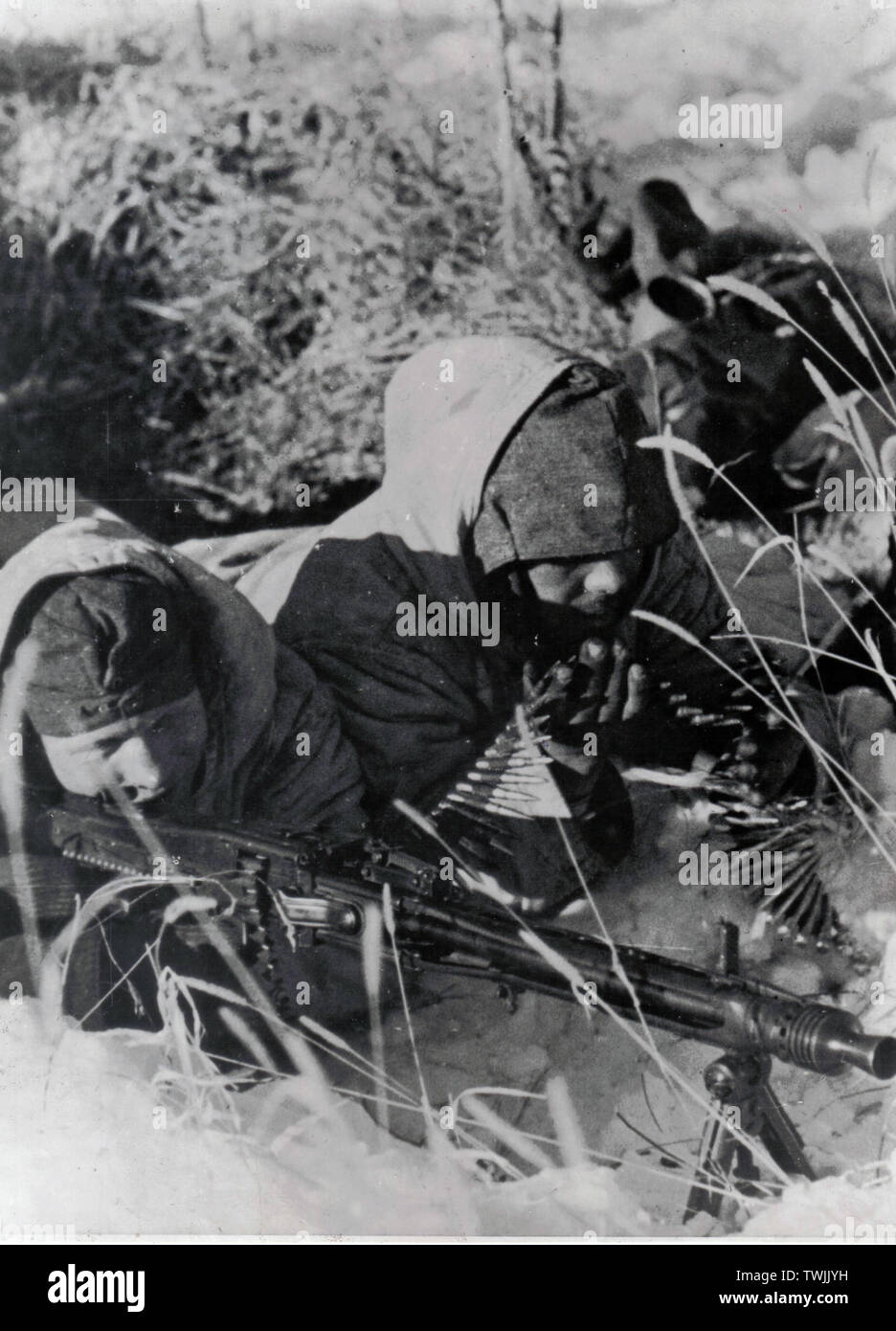 German Soldiers in Winter Parkas fire an MG42 on the Eastern Front 1944 Stock Photo