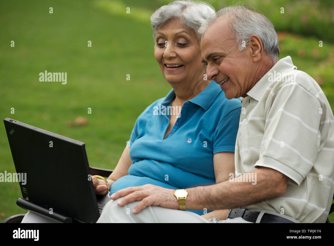 Couple working on a laptop and smiling Stock Photo - Alamy