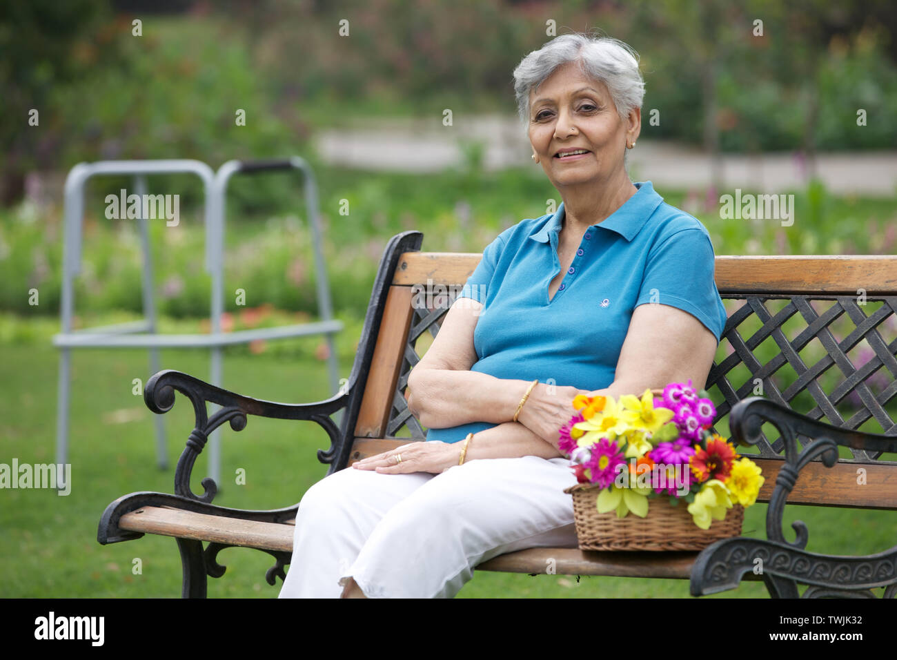 Old woman sitting on a park bench and smiling Stock Photo - Alamy