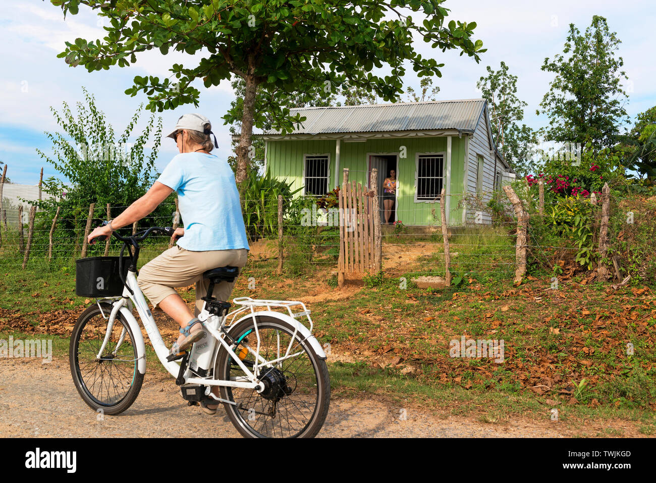 Female tourist on electric bike touring through the countryside at San Juan y Martinez, Pinar del Rio, Cuba Stock Photo