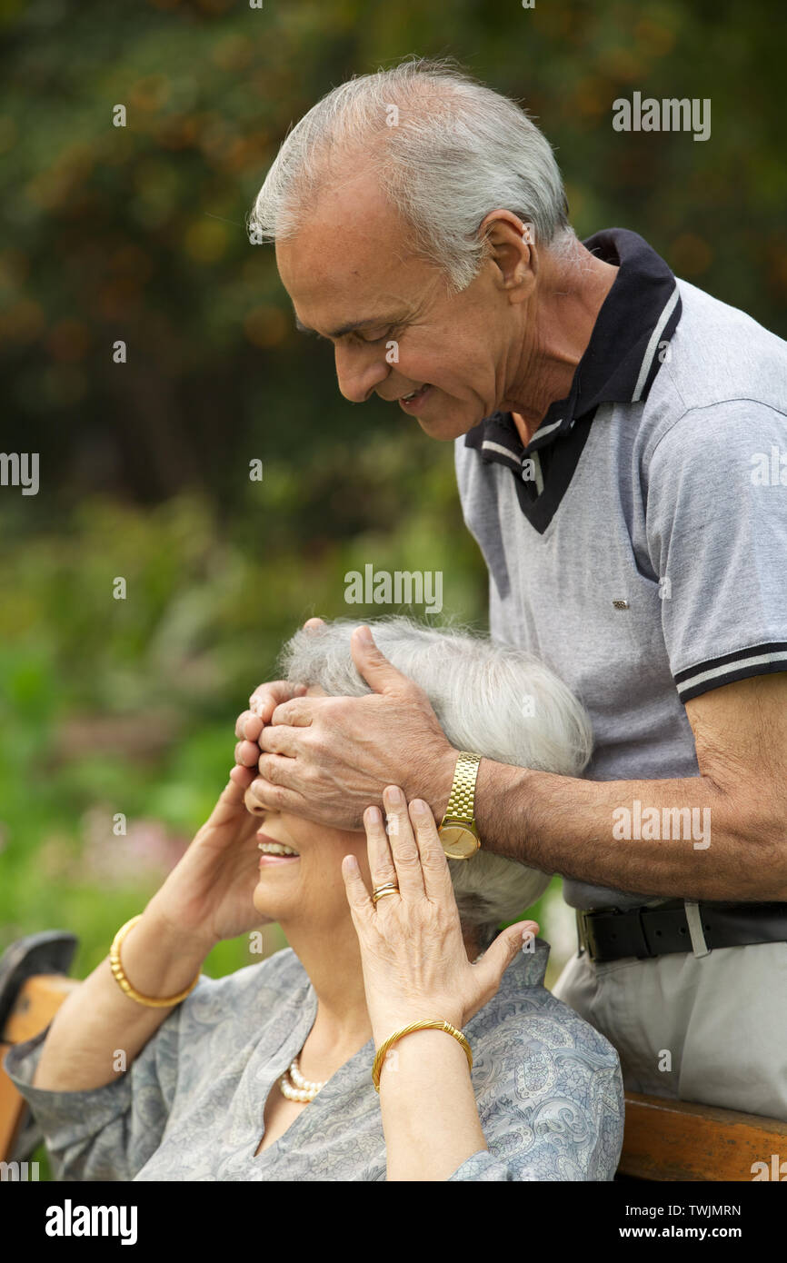 Old Man Covering Womans Eyes From Behind And Smiling Stock Photo Alamy