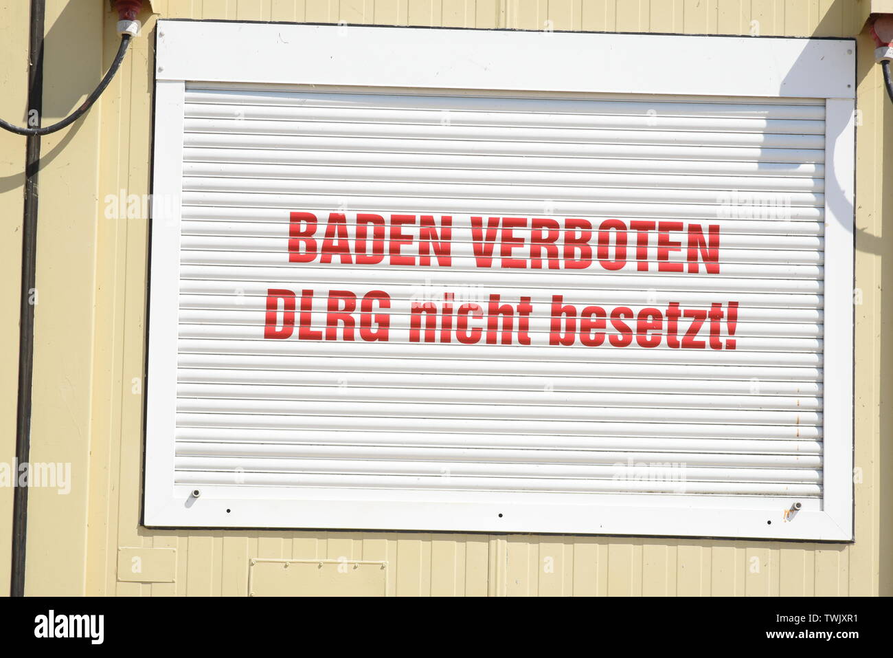 18 June 2020, Saxony-Anhalt, Mücheln: On the beach of the Geiseltalsee there is a lowered roller blind saying 'Baden verboten DRLG nicht besetzt! Photo: Waltraud Grubitzsch/dpa-Zentralbild/dpa Stock Photo