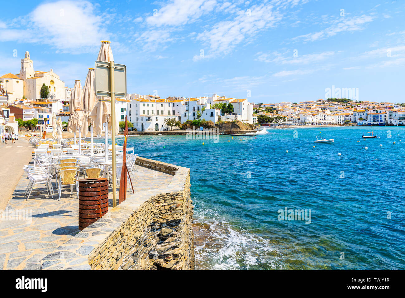 Restaurant tables on sea promenade in Cadaques port, Costa Brava, Spain Stock Photo