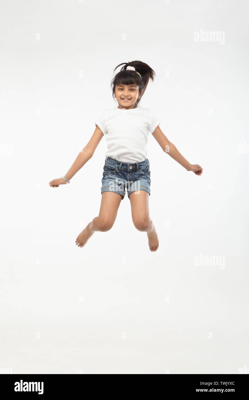 Girl jumping in air and smiling Stock Photo - Alamy