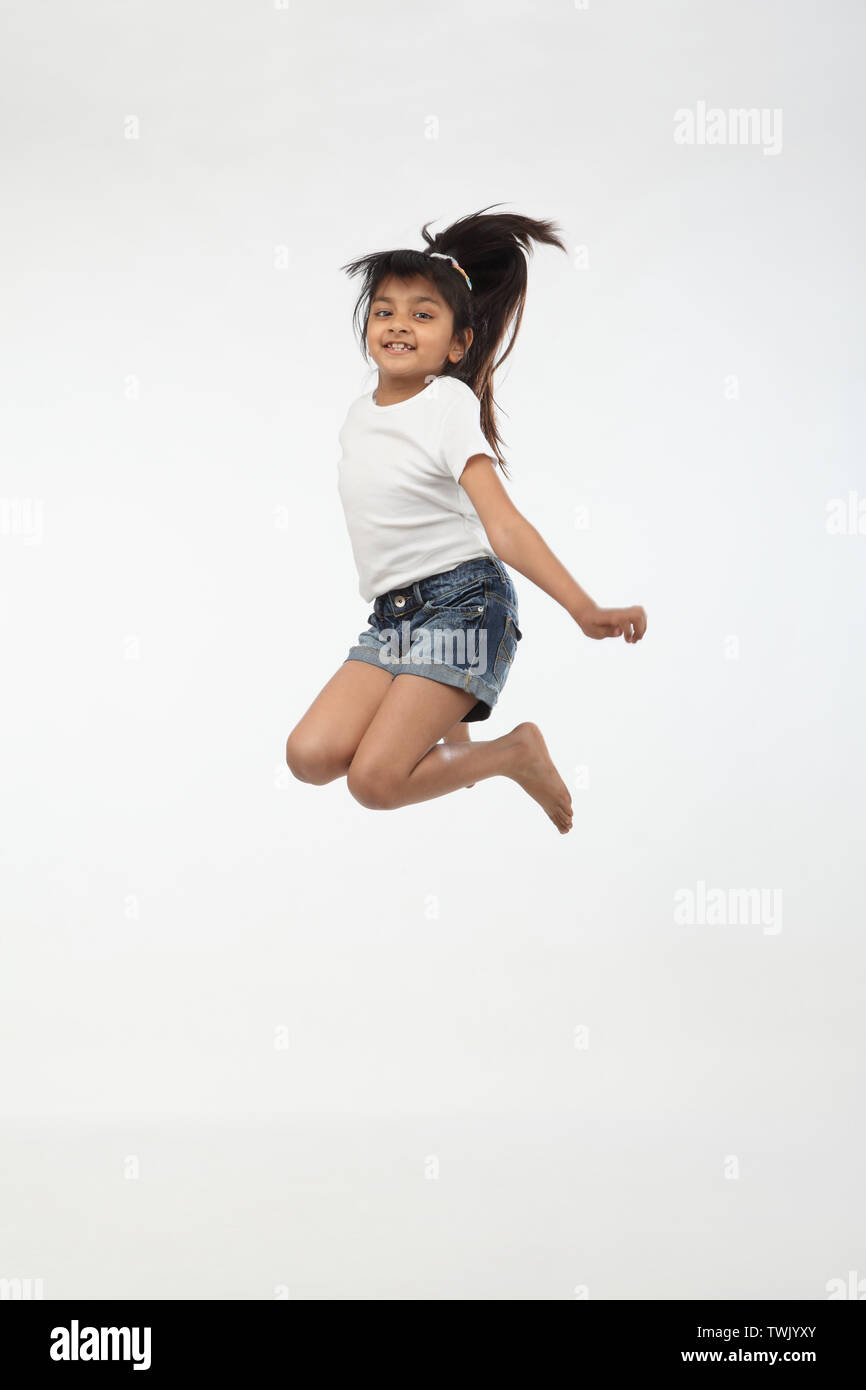 Girl jumping in air and smiling Stock Photo - Alamy