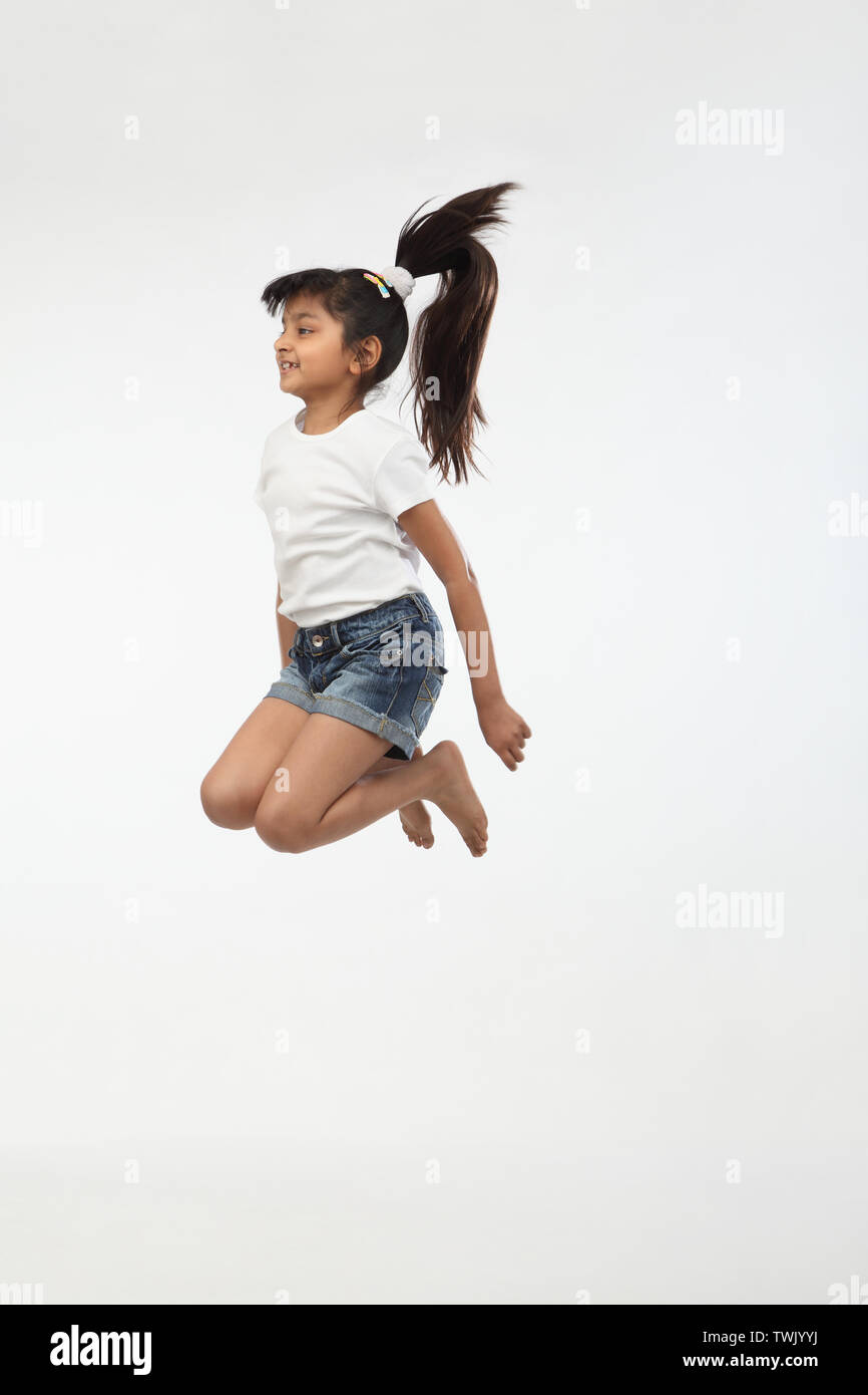 Girl jumping in air and smiling Stock Photo - Alamy