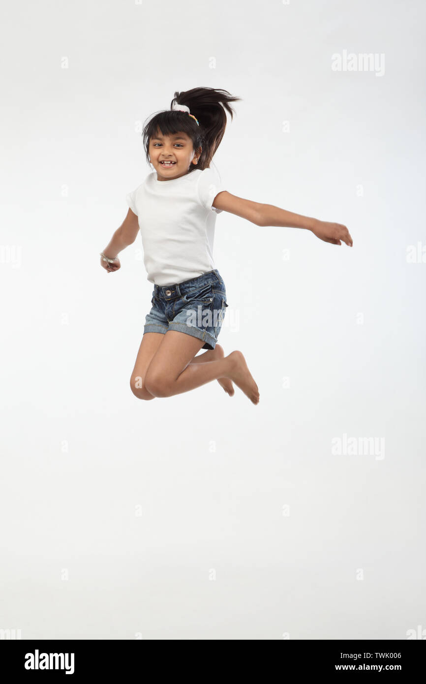 Girl jumping in air and smiling Stock Photo - Alamy