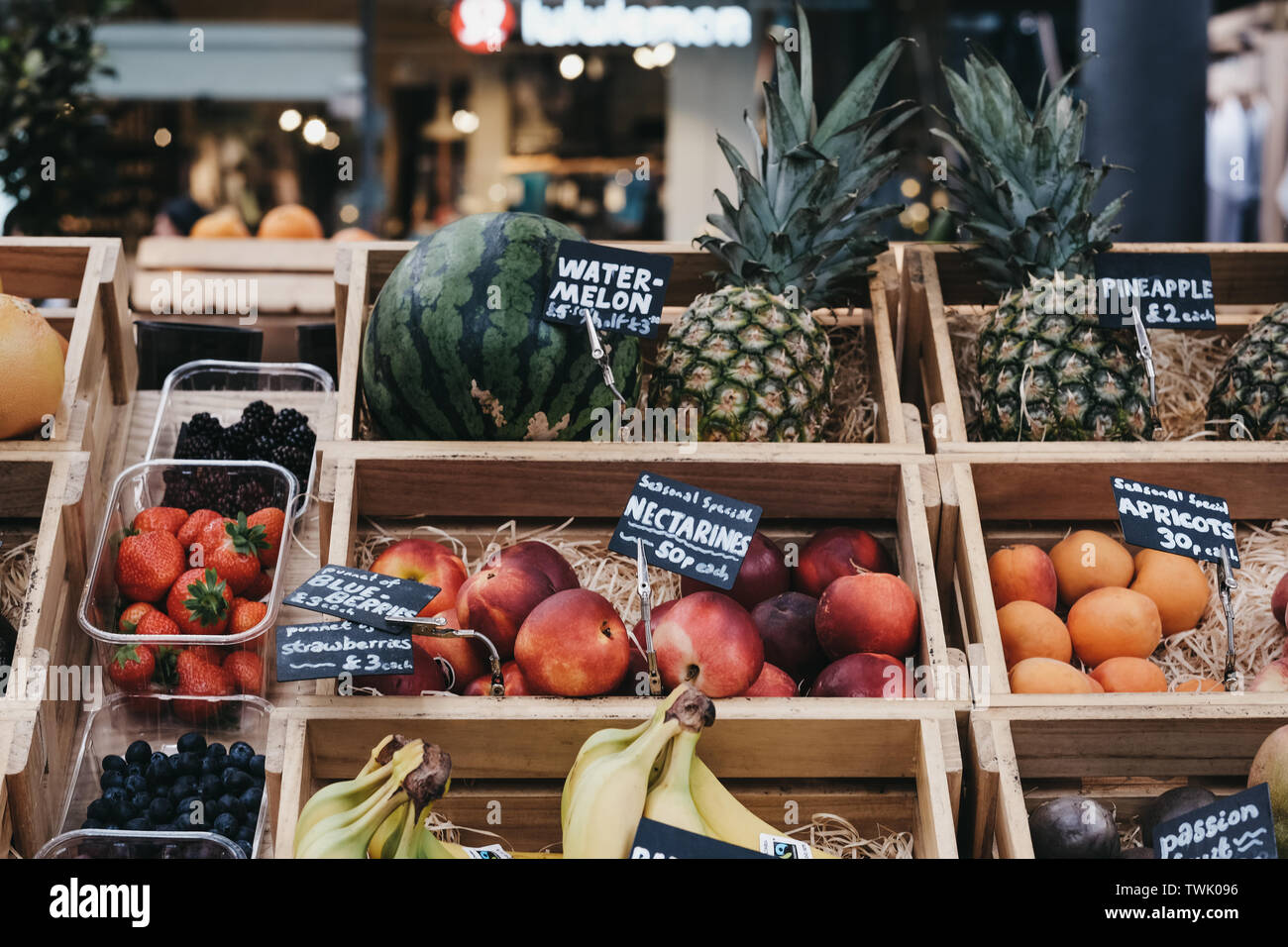 London, UK - June 15, 2019: Fresh fruits in wooden crates on sale at Spitalfields Market, one of the finest surviving Victorian Market Halls in London Stock Photo