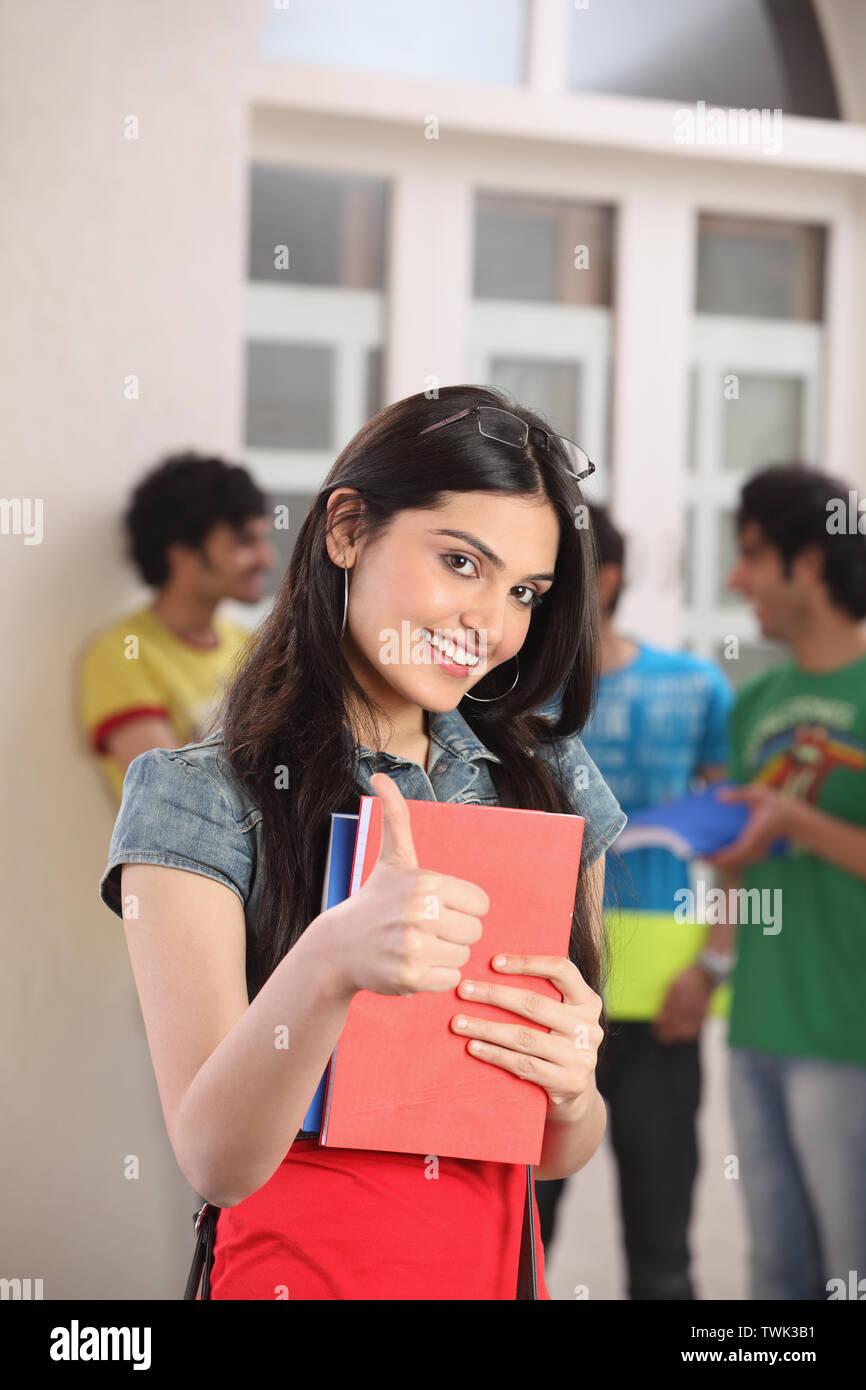 Portrait of a college student showing thumbs up sign and smiling Stock ...