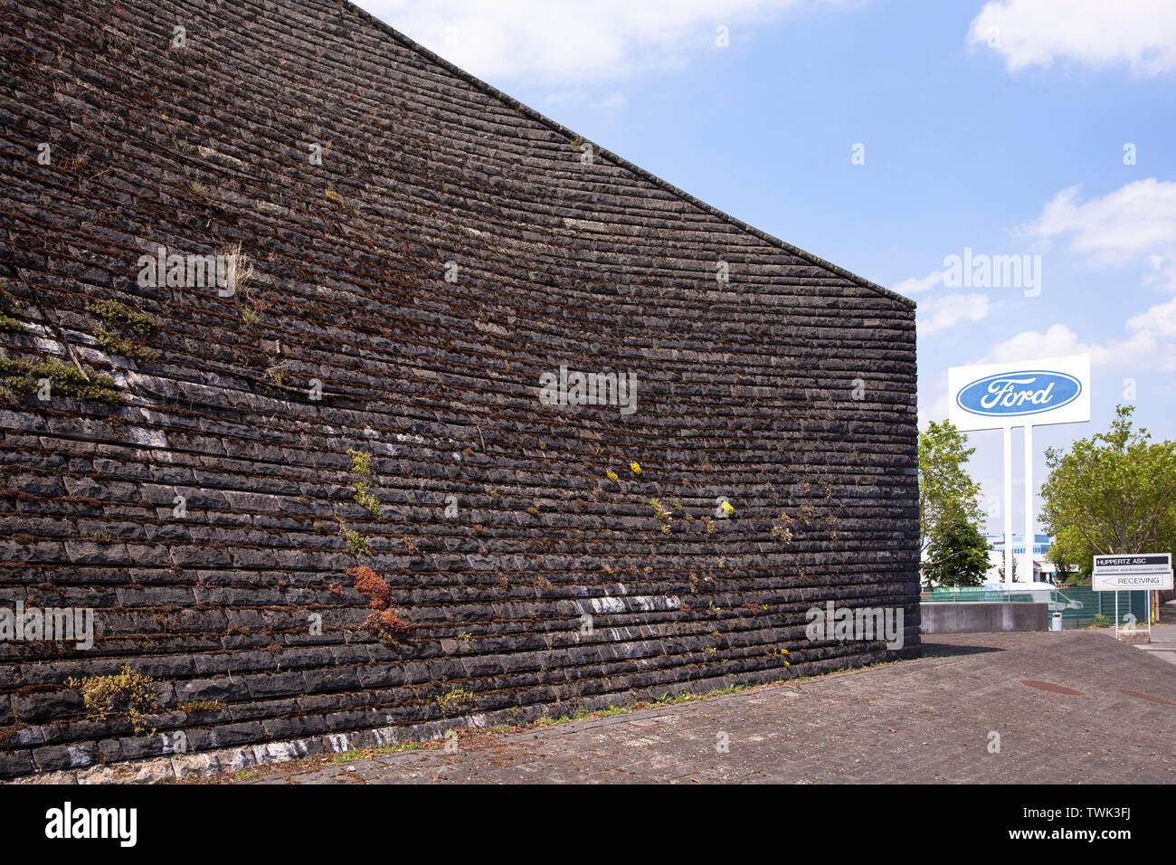 basalt facade of the flood pumping station at the river Rhine in Koeln-Niehl, the vegetation of the wall with moss and other plants is intentional, AS Stock Photo